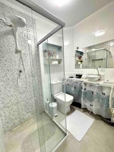 a bathroom with a shower and a toilet and a sink at Kitnet - São Vicente - Itararé in São Vicente