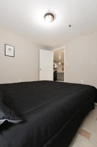 a bedroom with a black bed in a white room at Bright 2-Bed Haven Close to NYC in Jersey City
