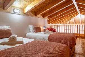 2 Betten in einem Zimmer mit Holzdecken in der Unterkunft City Hall Apartments in Vila Real