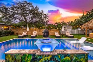 uma piscina com uma fonte no meio de uma casa em Bali Inspired home with Heated Pool, Sauna and Hot Tub! Close to Beach and Atlantic Ave em Delray Beach