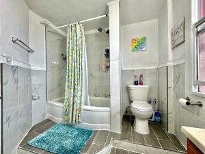 a bathroom with a shower and a toilet and a tub at Tiny Private Room on the 1st Floor Shared Bathroom near Airport and Downtown Seattle in Seattle