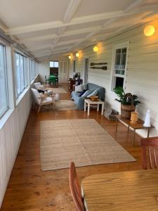 a living room with a couch and a table at Bermagui Bay Beach House 1, Best Beachside Location in Bermagui in Bermagui