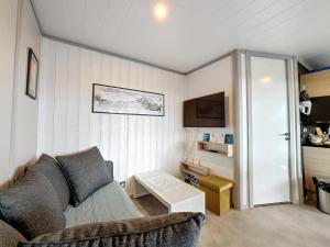 un salon avec un canapé et une table dans l'établissement Chalet de standing pour 4 pers., piscine couverte et chauffée, à deux pas de la plage, Wi-Fi gratuit - FR-1-361-515, à Jullouville