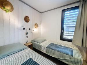 deux lits dans une chambre avec une fenêtre dans l'établissement Chalet de standing pour 4 pers., piscine couverte et chauffée, à deux pas de la plage, Wi-Fi gratuit - FR-1-361-515, à Jullouville 20 autres photos