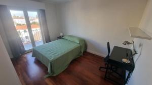 een slaapkamer met een bed, een tafel en een raam bij Apartamento Sonho Azores T5 in Ponta Delgada