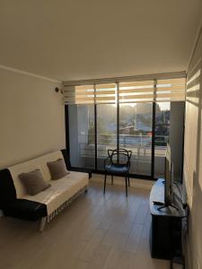 1 dormitorio con 1 cama, TV y ventana en Departamento en Collao cercano al terminal, en Concepción