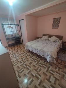 1 dormitorio con 1 cama y suelo de madera en Hostal el hermanito, en San Pedro de Atacama