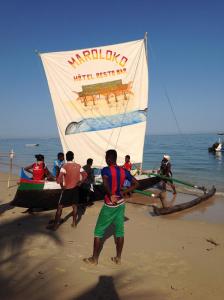 a group of people on the beach with a sail boat at Villa Maroloko in Ifaty