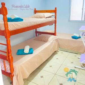 מיטה או מיטות קומותיים בחדר ב-Pousada Lilás