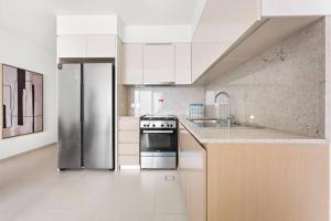 a kitchen with a stove and a refrigerator at Burj Royale 2 Bed with Burj Khalifa View in Dubai