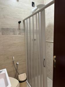 a bathroom with a shower with a toilet and a sink at Kitnet no Paraíso in São Sebastião do Paraíso +3 photos