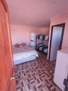 1 dormitorio con 1 cama y 1 litera en Hostal el hermanito, en San Pedro de Atacama