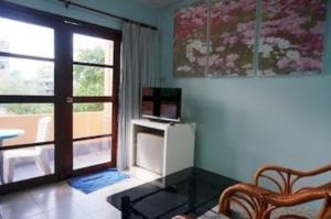 a living room with a television and a window at Royal Beach Guest House in Hua Hin