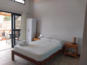1 dormitorio con 1 cama y puerta que da a un patio en Casuarinas del Mar Habitacion Cerro 2, en Canoas de Punta Sal