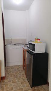 a kitchen with a microwave on top of a refrigerator at Casuarinas del Mar Habitacion Cerro 2 in Canoas De Punta Sal