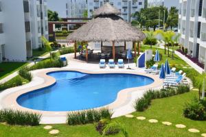 a swimming pool with chairs and a gazebo at Casa Parota Manzanillo in Manzanillo +29 photos