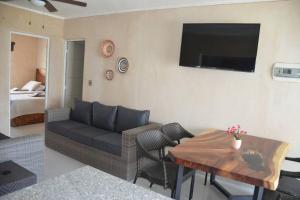 a living room with a couch and a table at Casa Parota Manzanillo in Manzanillo