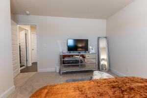 een slaapkamer met een bed en een tv op een dressoir bij Luxury Bedroom with Private Bath near Atlanta Airport in Hampton