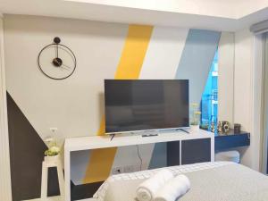 a bedroom with a tv on a colorful wall at Happy Modern Studio in Azure in Lagundi