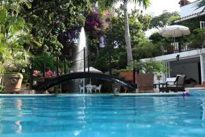 una piscina con un puente y una fuente en Villa de Lena, en Cuernavaca