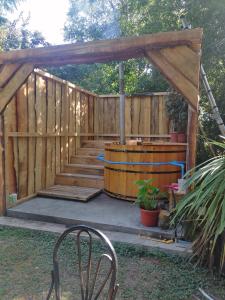 een houten terras met een tuinhuisje en een vat bij Cisnes del tolten in Freire