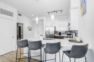 a kitchen with a white counter and four chairs at Downtown Tampa Gem 1-BD w/Pool, Gym, & Sky Lounge in Tampa