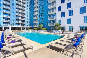 a swimming pool with lounge chairs and a hotel at Downtown Tampa Gem 1-BD w/Pool, Gym, & Sky Lounge in Tampa