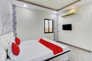 a white bedroom with a bed and a tv at Hotel O One Plus Inn in Itwāri