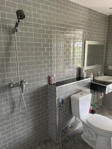 een badkamer met een wit toilet en een wastafel bij Bangsaray Beach Resort in Bang Sare