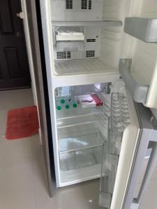 an empty refrigerator with its door open in a kitchen at Bangsaray Beach Resort in Bang Sare