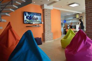 a waiting room with colorful chairs and a tv at Hostel Fun in Rijeka
