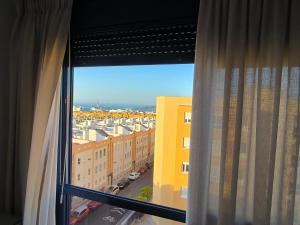 a window with a view of a city with buildings at Blue House in Las Palmas de Gran Canaria