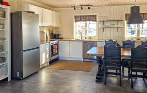 a kitchen with a table and a stainless steel refrigerator at 3 Bedroom Gorgeous Home In Sysslebck in Sysslebäck