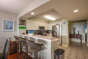 a large kitchen with a counter and a refrigerator at Windy Hill Dunes 104 condo in Myrtle Beach