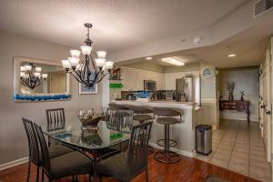a dining room and kitchen with a glass table and chairs at Windy Hill Dunes 104 condo in Myrtle Beach