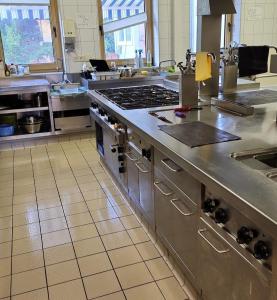 una cucina con un grande piano di lavoro in acciaio inossidabile di Hotel Neue Krone a Markt Erlbach