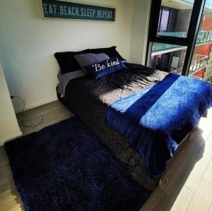- un lit avec une couette bleue et un oreiller dans l'établissement DOWNTOWN MIAMI, à Miami
