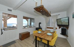 a dining room with a wooden table and yellow chairs at 4 Bedroom Amazing Home In Banj in Banj
