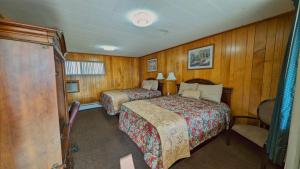 una habitación de hotel con 2 camas y una silla en Delta Motel, en Bay City