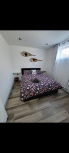 a bedroom with a bed with flowers on it at L'hêtre au Sommet (gîte) in Sainte Anne des Lacs