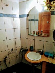 W łazience znajduje się umywalka i lustro. w obiekcie VILLA LENA - ΑΝΔΡΟΣ w mieście Batsi