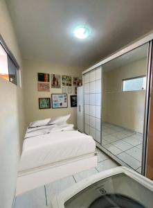 a bedroom with a bed and a shower and a mirror at Apartamento próximo ao Parque do Povo em Campina Grande in Campina Grande