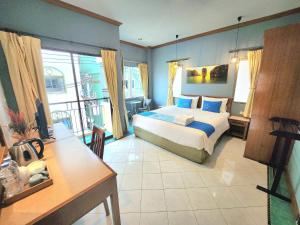 1 dormitorio con cama, mesa y escritorio en Sea Front Home Hotel - Patong Beach, en Patong Beach