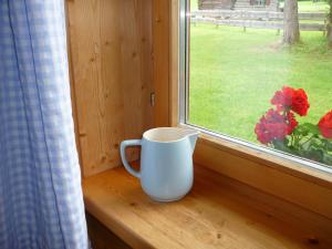 eine weiße Kaffeetasse auf einem Fensterbrett in der Unterkunft Am Schlierbach in Unterwössen