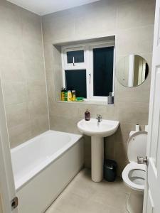 a bathroom with a tub and a sink and a toilet at 9 probyn close in Bristol