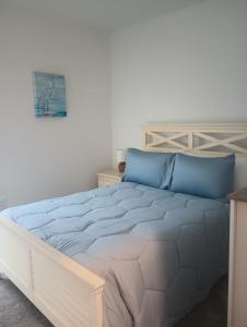 Coastal retreat- monthly stay في إدج ووتر: غرفة نوم بسرير كبير مع وسائد زرقاء