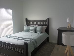 Coastal retreat- monthly stay في إدج ووتر: غرفة نوم بسرير ذو شراشف ووسائد بيضاء