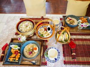 une table avec des assiettes de nourriture sur une table dans l'établissement Malulee Homestay/Cafe/Massage, à Lampang