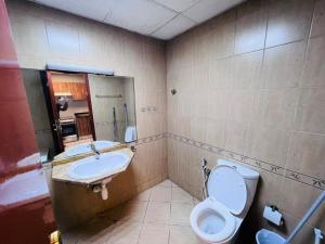 a bathroom with a toilet and a sink at Studio Apartment in Ajman 