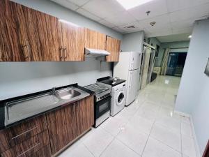 a small kitchen with a sink and a stove at Studio Apartment in Ajman 